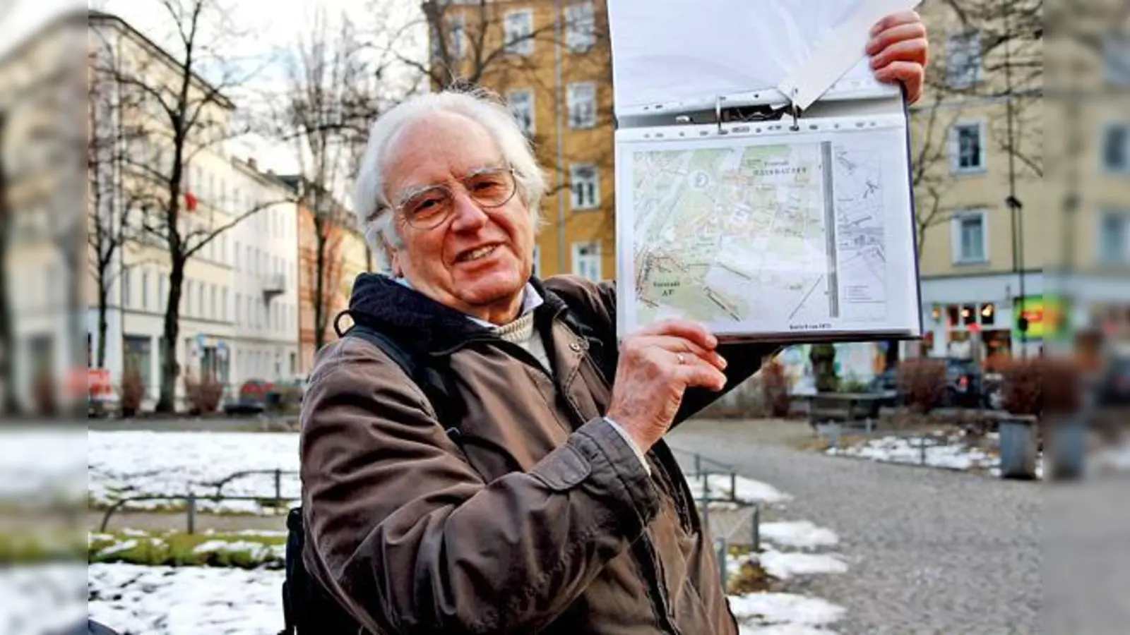 Der Haidhausener Stadtteilexperte Johann Baier zeigt am Weißenburger Platz eine alte Karte des Franzosenviertels.	 (Foto: js)