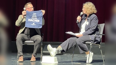 „Sollte, hätte, würde, könnte - Machen”, Jürgen Andre zeigt Katrin Schmidt den neuen Stoffbeutel des Wirtschaftsverbands. (Foto: pst)