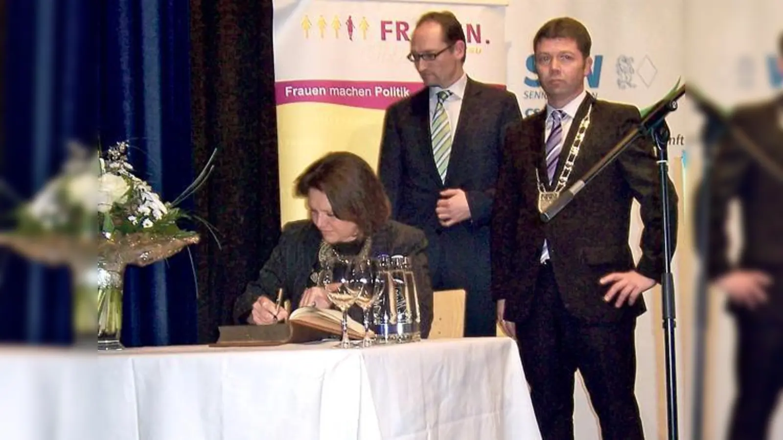 Aigner vor dem Plakat »Frauen machen Politik«, Seidenath und Felbermeier schauen ihr zu. 	 (Foto: VA)