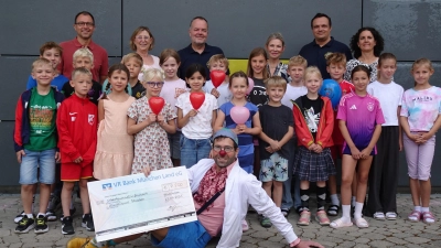 Hinten von links: Alexander Bolotnik vom Elternbeirat, Schulleiterin Sabine Schmidt, Lions-Präsident Wolfgang Frank, Alla Mühlenfeld vom Elternbeirat, René Beyer, Organisator des Spendenlaufs, und Sportlehrerin Cornelia Kellerer. Unten: Klinikclown Georg Schulze alias Dr. Batscho. In der Bildmitte: viele kleine Athleten der Grundschule Feldkirchen. (Foto: Lionsclub Aschheim Herzog Tassilo III.)