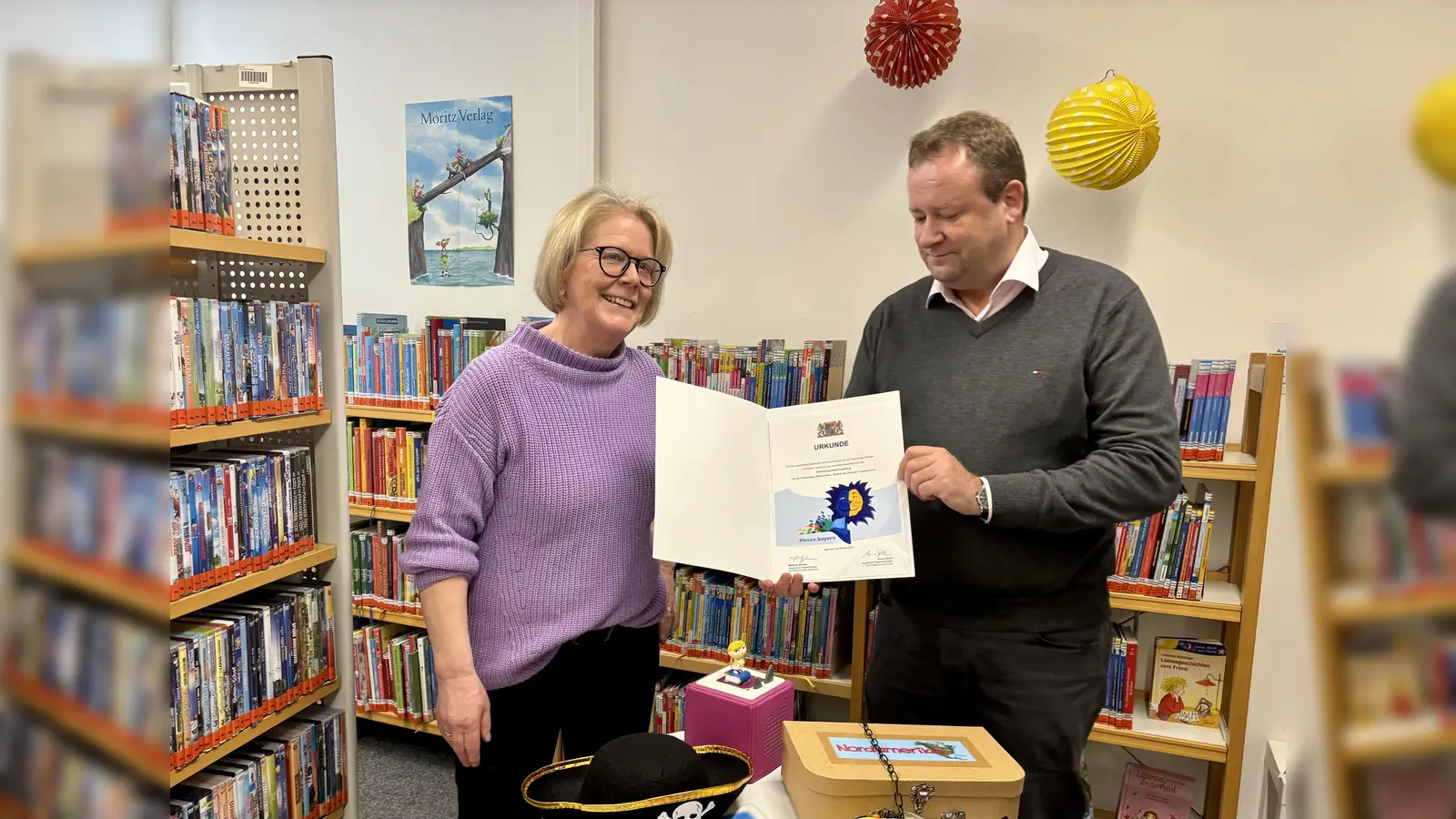 Bürgermeister Peter Köstler gratulierte der Gräfelfinger Gemeindebibliothek zum Titel „Partner der Schulen” und überreichte der Leiterin Elke Naeve die Urkunde. (Foto: Ulrike Seiffert)