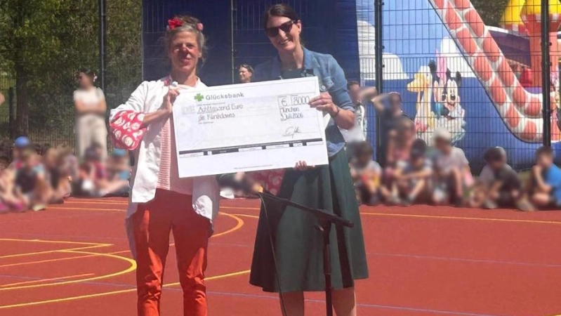 Im Rahmen des Sommerfests der Schule überreichte Schulleiterin Eva-Maria Güttler (rechts) der KlinikClownin „Rhabarber Rosella” die Spende aus dem Benefizlauf. (Foto: Grundschule Markgrafenstraße)