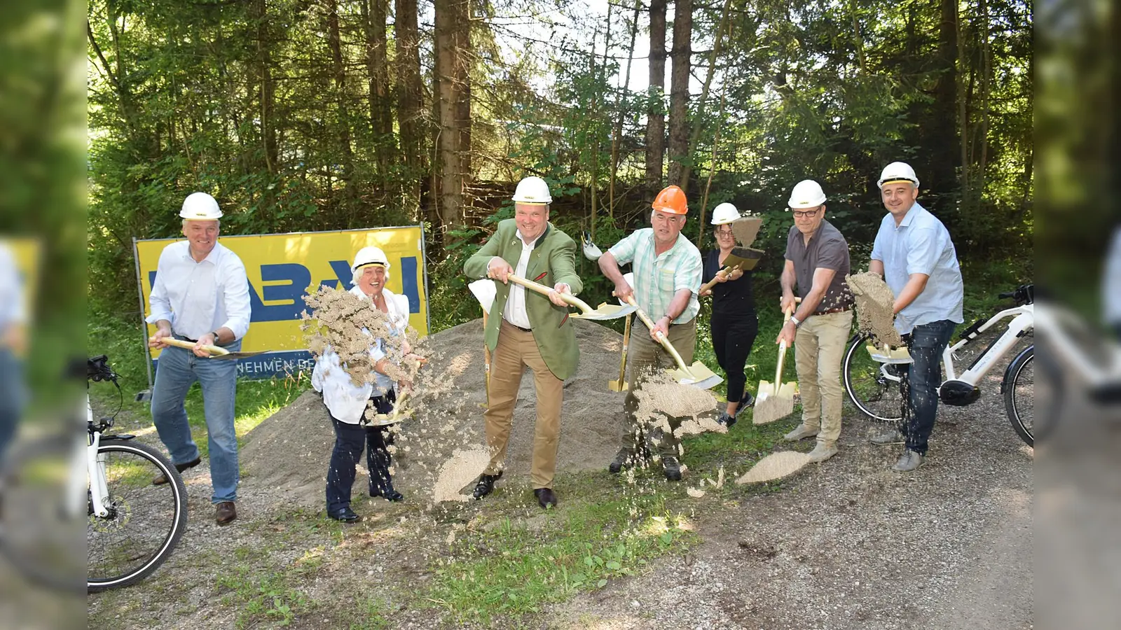 Bürgermeister Stefan Schelle, Bürgermeisterin Barbara Bogner, Landrat Christoph Göbel, Alfred Strauch (Bayerische Staatsforsten), Sylvia Wolfensberger, LRA München, Richard Schmidt (Schmidt & Potamitis Bauingenieure) sowie Michael Mittermair (Fa. HABAU) beim gemeinsamen Spatenstich. (Foto: LRA)