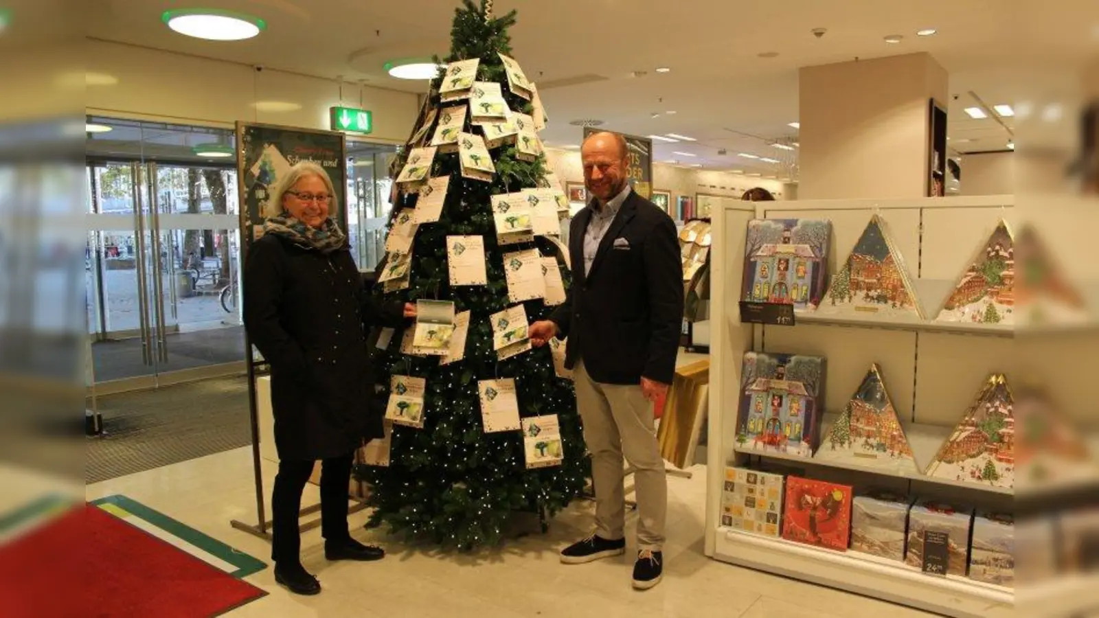Seniorenbeirätin Ingeborg Staudenmeyer zusammen mit Christian Lüttin, Geschäftsführer der Galeria Kaufhof am Rotkreuzplatz, am Charity-Weihnachtsbaum. (Foto: sb)