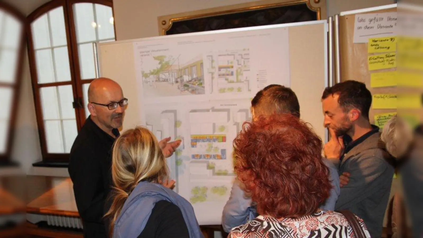 „Die Stadt München will den besonderen Charakter des Viktualienmarktes unbedingt beibehalten”: Architekt Rainer Hofmann (l.) erklärte interessierten Bürgern die möglichen Umbauvarianten. (Foto: us)