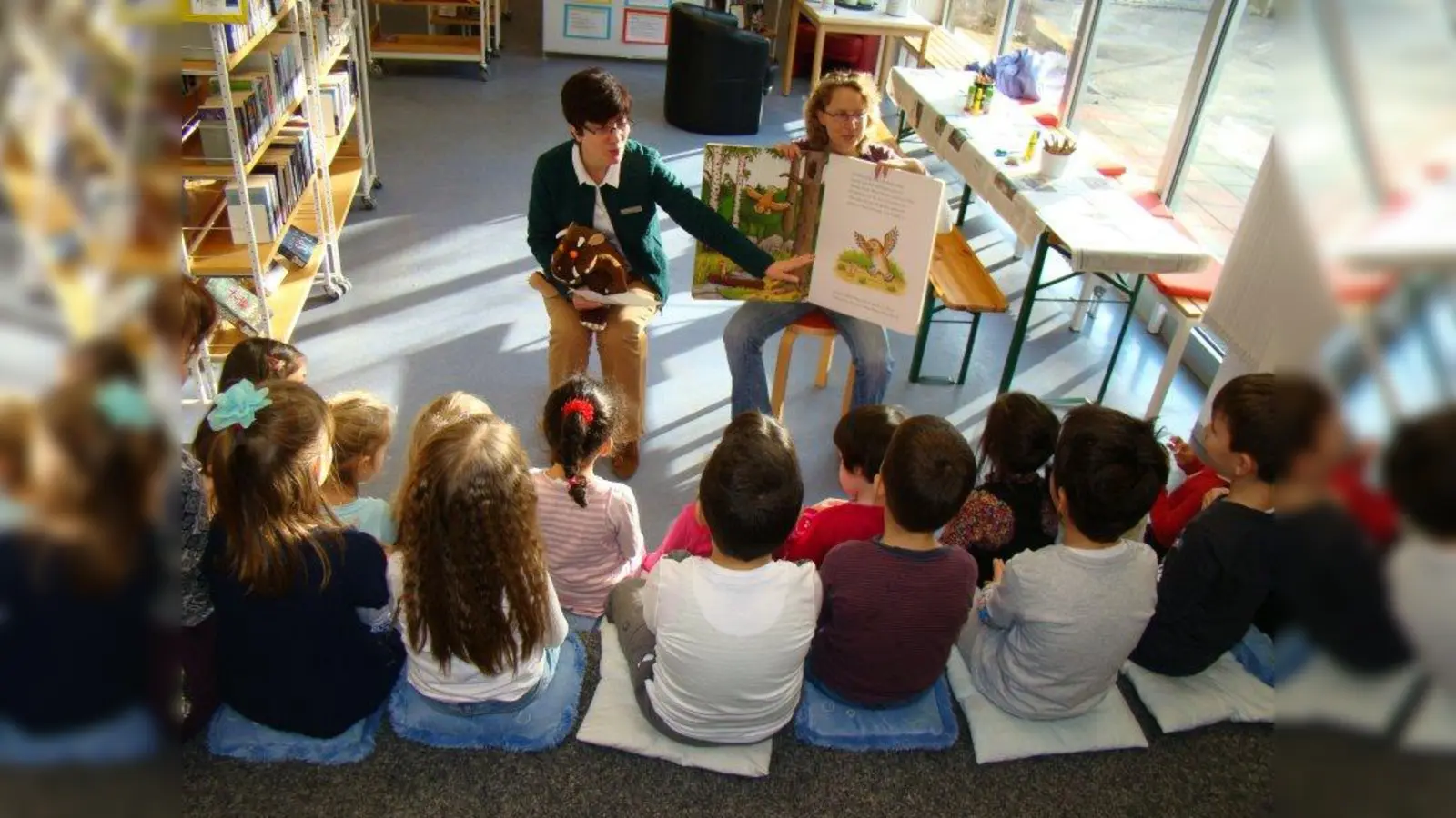 Gülay Savasci (links) und Judith Richter lesen den Kindergartenkindern den Grüffelo vor. (Foto: pst)
