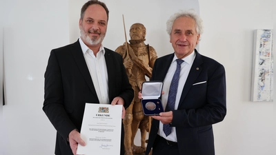Landrat Helmut Petz (r.) überreicht OB Tobias Eschenbacher die Kommunale Verdienstmedaille in Bronze. (Foto: LRA Freising)