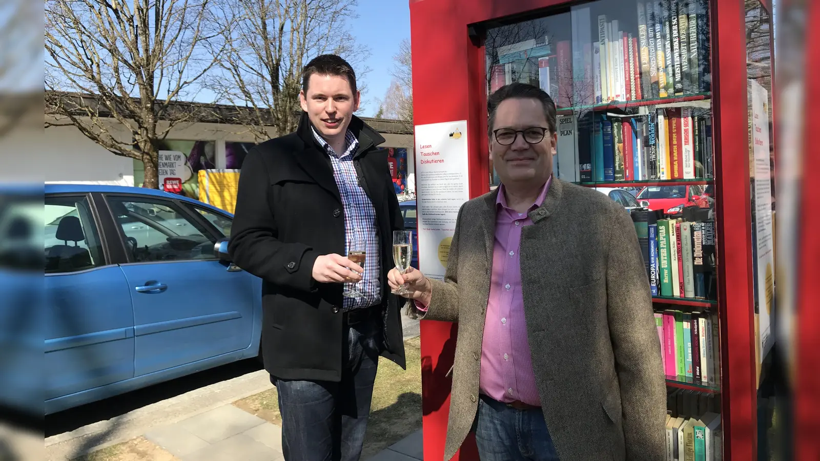 BA-16-Chef Thomas Kauer und der Vorsitzende des Vereins „Leben in Waldperlach“, Andreas Burkhardt stießen auf die Eröffnung des ersten „Offenen Bücherschranks“ in Waldperlach an. (Foto: hw)