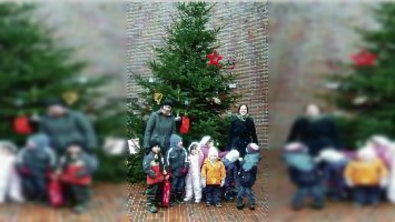 Ute Hippeli, Leiterin des Caritas-Hauses für Kinder, und Valerie Roeder, pädagogische Fachkraft, freuen sich mit den Kindern über den Baum.	  (Foto: VA)