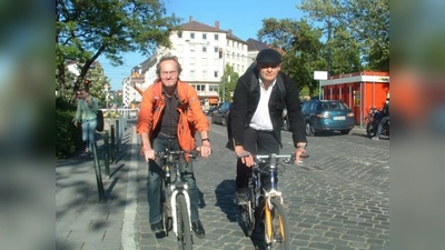 Die Radler rumpeln mehr schlecht als recht über die Kopfsteinpflaster-Furt: Roland Zintl (l.) und Gunter Schäfer von der Fraktion der Grünen im BA hoffen nicht nur auf ein besseres Miteinander aller Verkehrsteilnehmer am Rotkreuzplatz, sondern auch auf reale Verbesserungen für den Radverkehr. (Foto: bb)