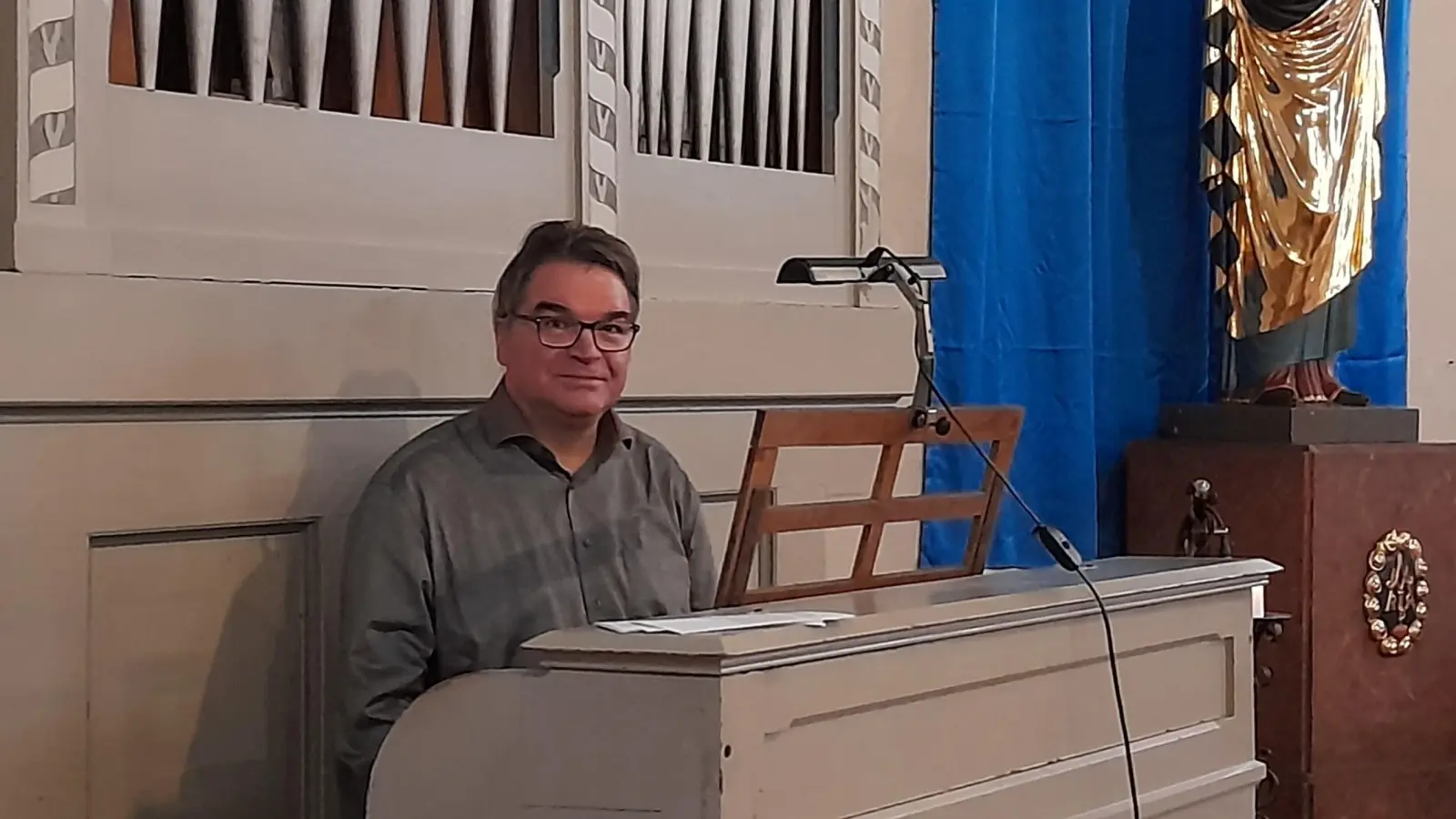 Alexander Pointner (54) ist der neue Kirchenmusiker im Pfarrverband Westend. Hier sitzt er an der kleinen Orgel in St. Rupert. (Foto: Beatrix Köber)