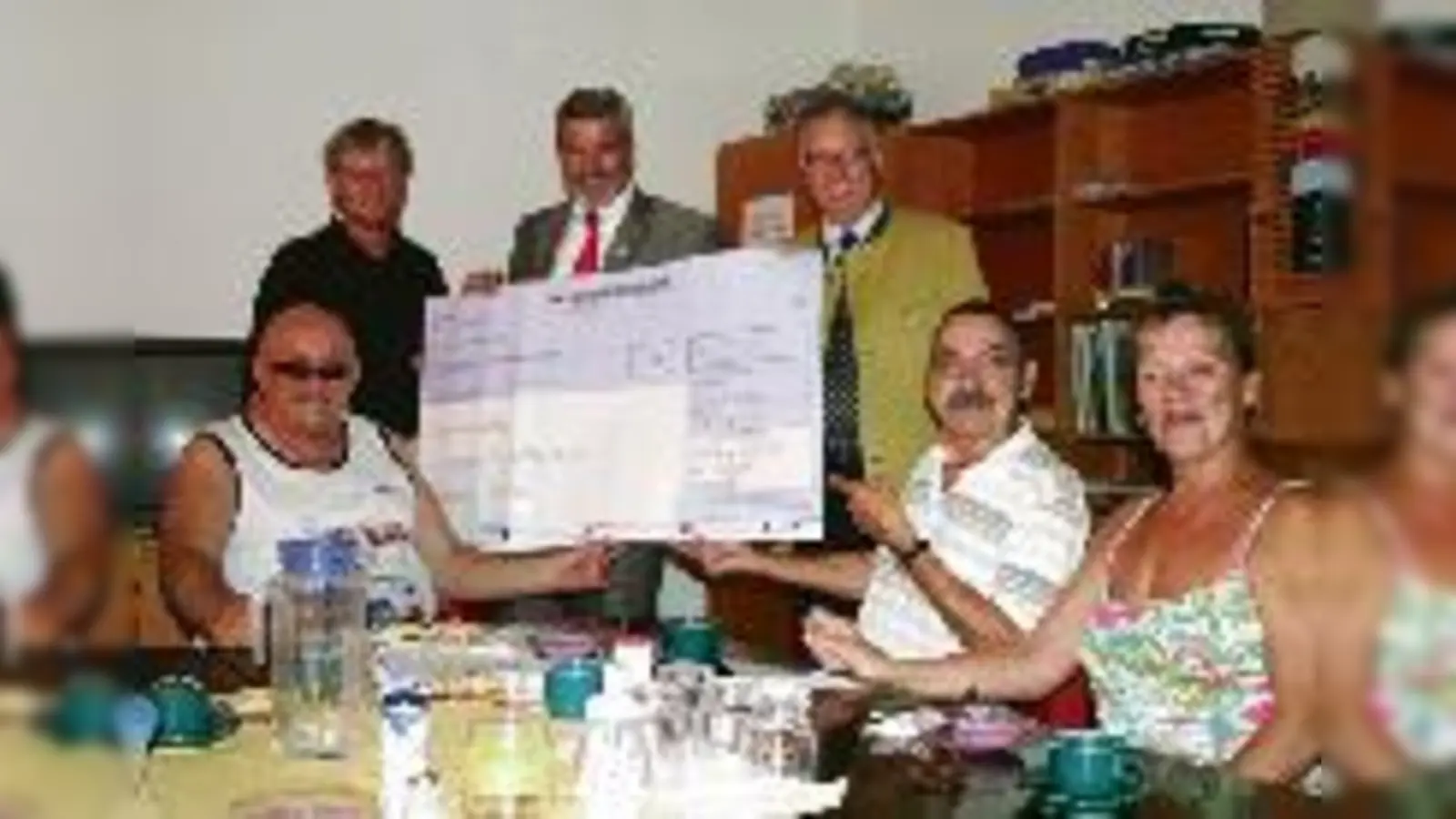 Pfarrer Hans M. Schroeder freut sich über 15.300 Euro für die Kirchenküche, überreicht von Stephan Reinhold und Eugen Turi für die Rotary-Clubs der Region München (stehend, von links).  (F.: em)