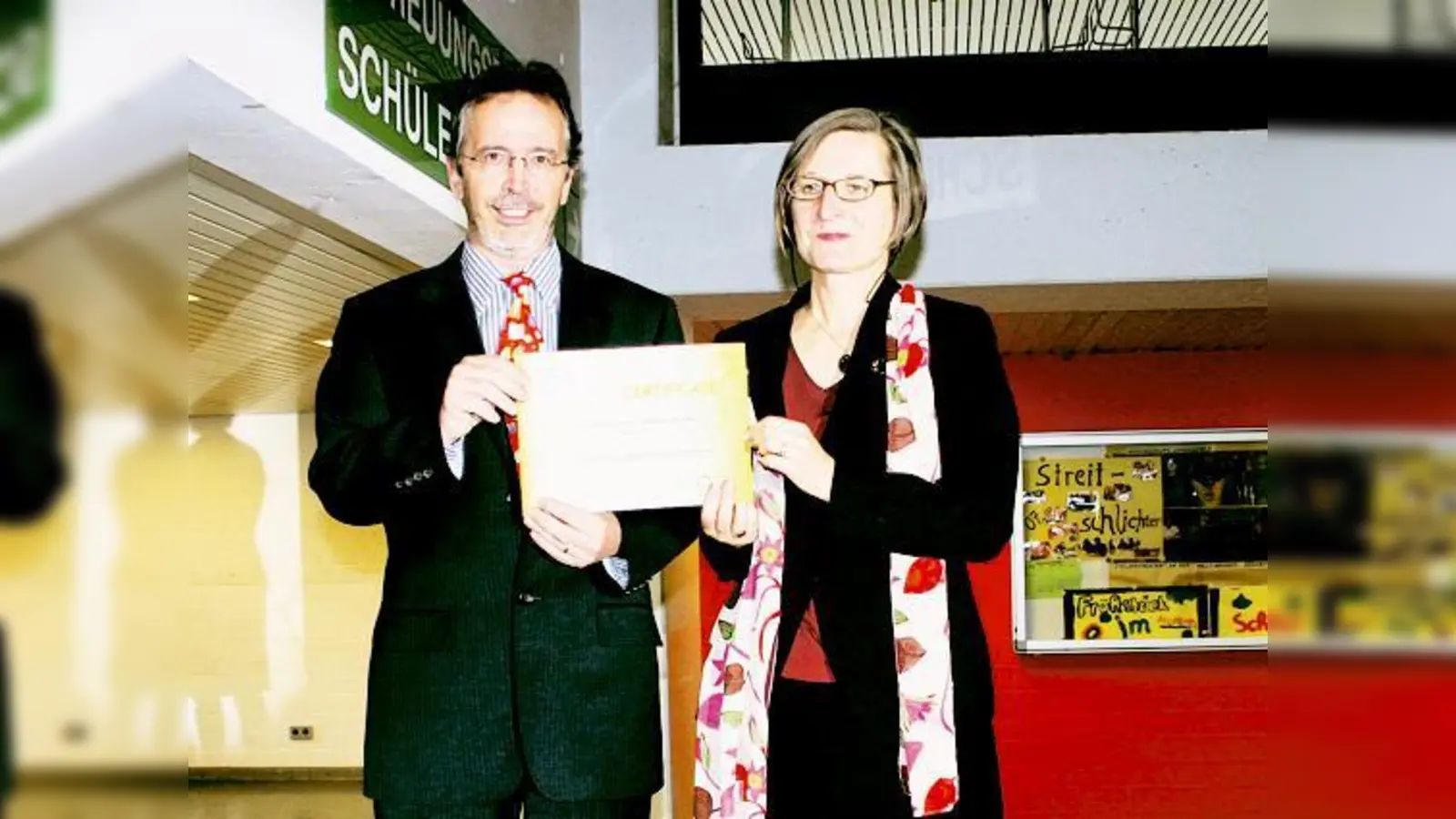 Volker Hörold, Bundeskoordinator der UNESCO-Projektschulen, übergibt Schulleiterin Cornelia Folger die Anerkennungsurkunde. 	 (Foto: mka)