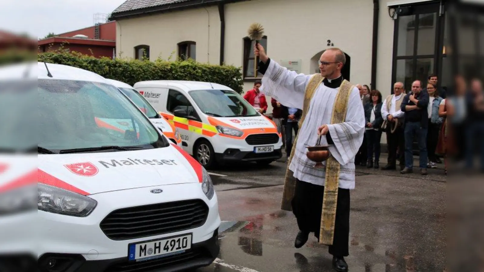 Pfarrvikar Martin Siodmok in Aktion: Elf neue Fahrzeuge segnete er beim Sommerfest der Malteser. (Foto: Julia Krill)