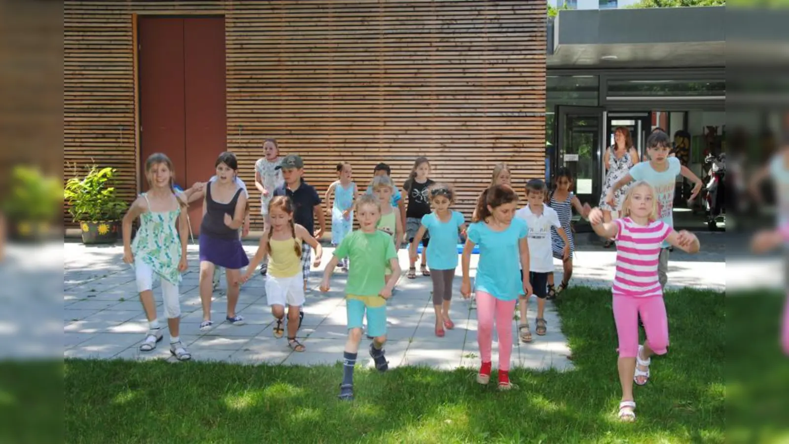 Hier üben die Betreuerinnen mit den Kindern den „Cha Cha Slide“, ein Tanz, der beim Jubiläum des Kooperationspartners Spiellandschaft Westkreuz aufgeführt wurde – der zur Freude der Eltern aber auch beim Sommerfest nochmal gezeigt wird. (Foto: Eva Schraft)