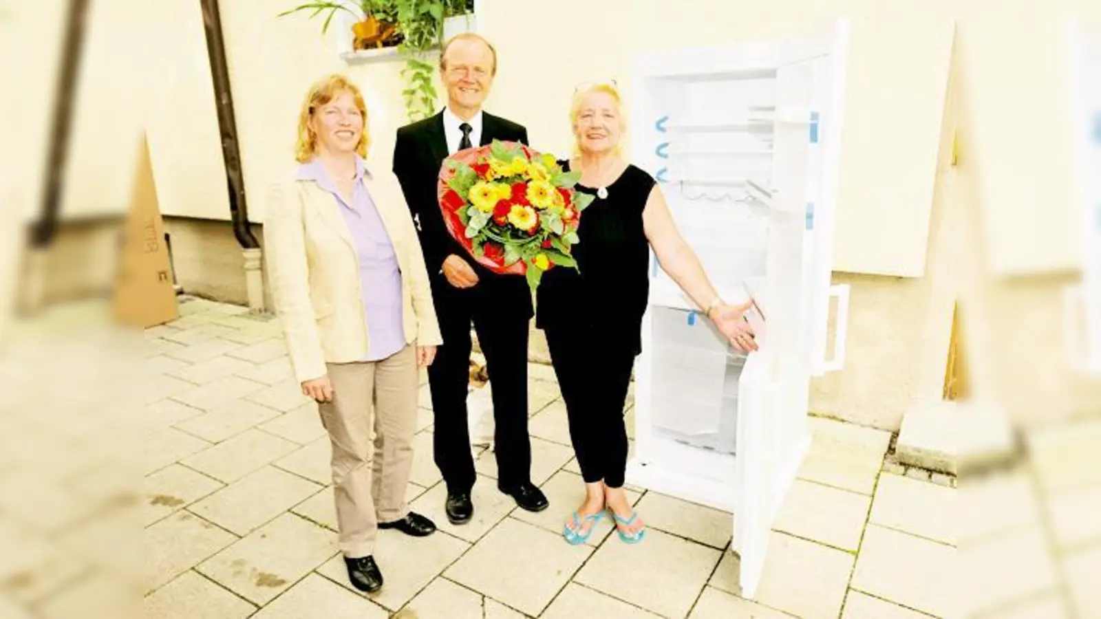 Ruth Waldmann, Prokuristin der AWO, und Dr. Kurt Mühlhäuser, Vorsitzender der SWM-Geschäftsführung, übergeben Regina H. einen Kühlschrank.  (Foto: SWM)