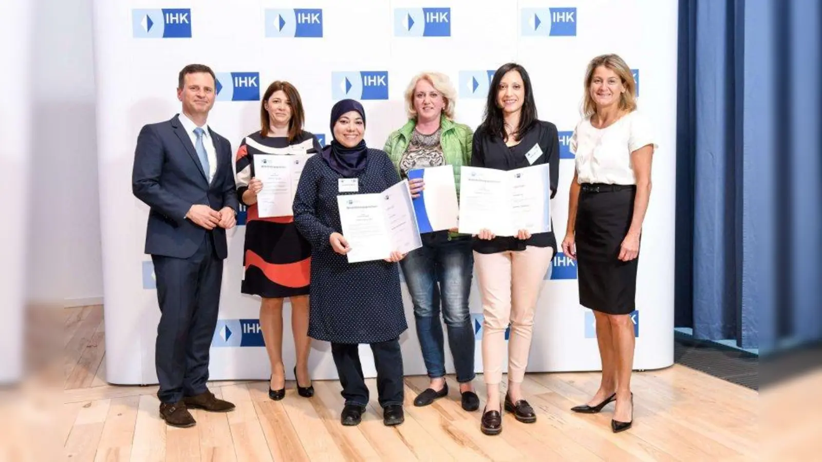 Dr. Manfred Gößl (stellv. Hauptgeschäftsführer der IHK für München und Oberbayern) (links außen) und Mechthilde Wittmann, MdL (Integrationsbeauftragte der Bayerischen Staatsregierung) (rechts außen) mit den Absolventen der Fortbildungsabschlüsse (von links): Ljubica Andric (geprüfte Controllerin aus Kroatien), Loubna El Hajjar (geprüfte Wirtschaftsfachwirtin aus Marokko), Olga Schulz (geprüfte Controllerin aus der Ukraine), Serena Riccetti (geprüfte Controllerin aus Italien). (Foto: © Tobias Hase / IHK)