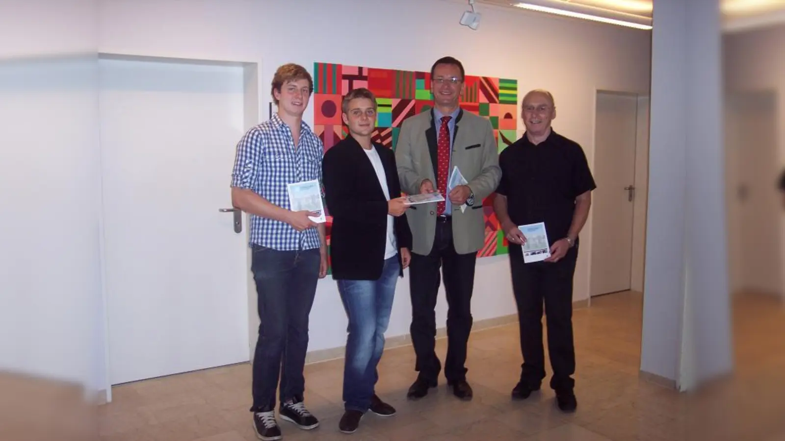 Die Macher und Helfer halten die druckfrische Broschüre in den Händen (v.l.): Die Abiturienten des Karl-Spitzweg-Gymnasiums Matthias Räder und Robert Lung, OB Andreas Haas und P-Seminar-Leiter Lothar Richter (Foto: Ellen Teßmann)