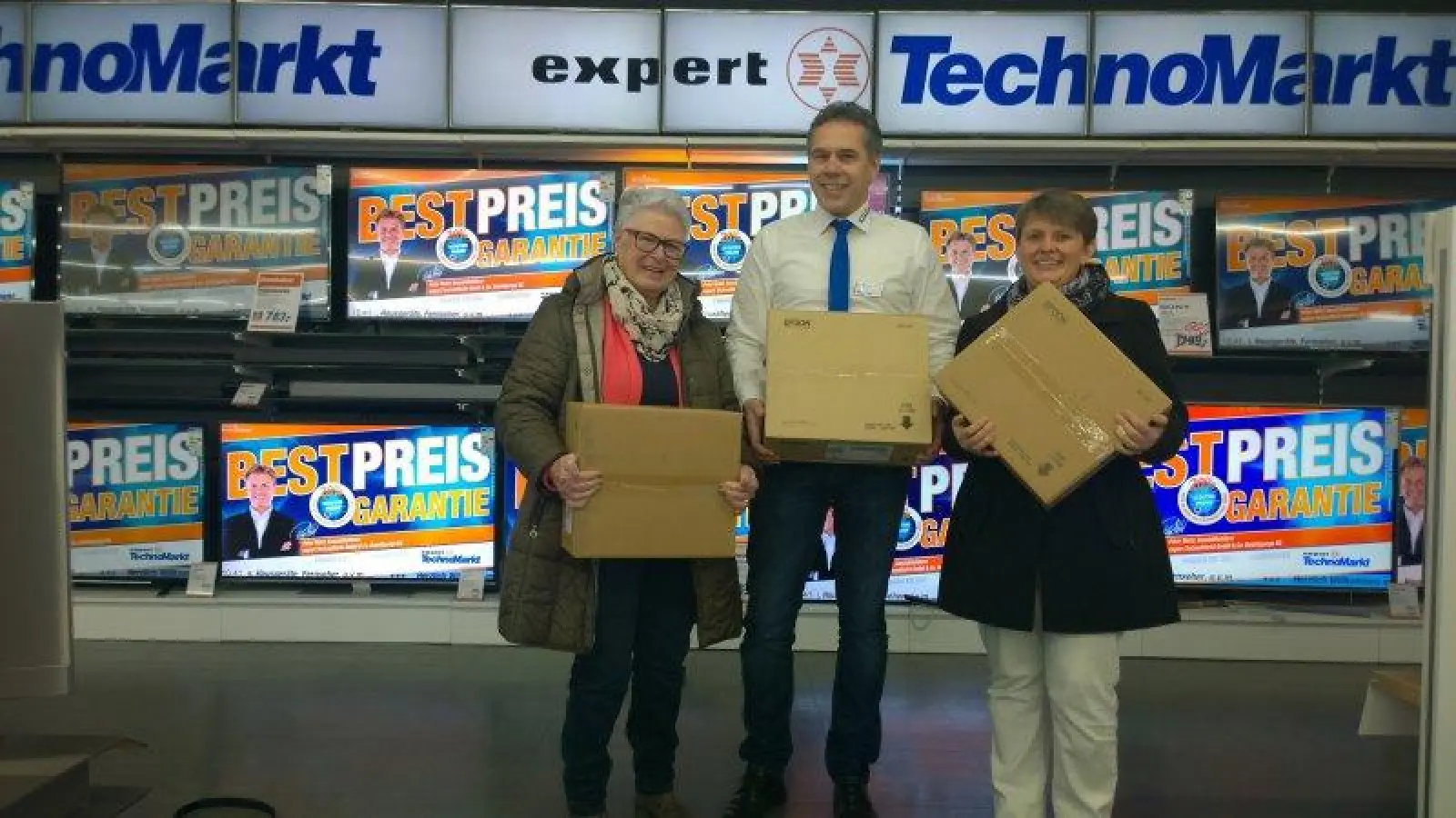 Freuen sich über die neuen Geräte, die ein Mitarbeiter des Expert Techno Marktes überreichte: Hanneli Müller vom Förderverein der Kerschensteiner Schule und Elternbeiratsvorsitzende Diana Veigl. (Foto: Kerschensteiner Schule)