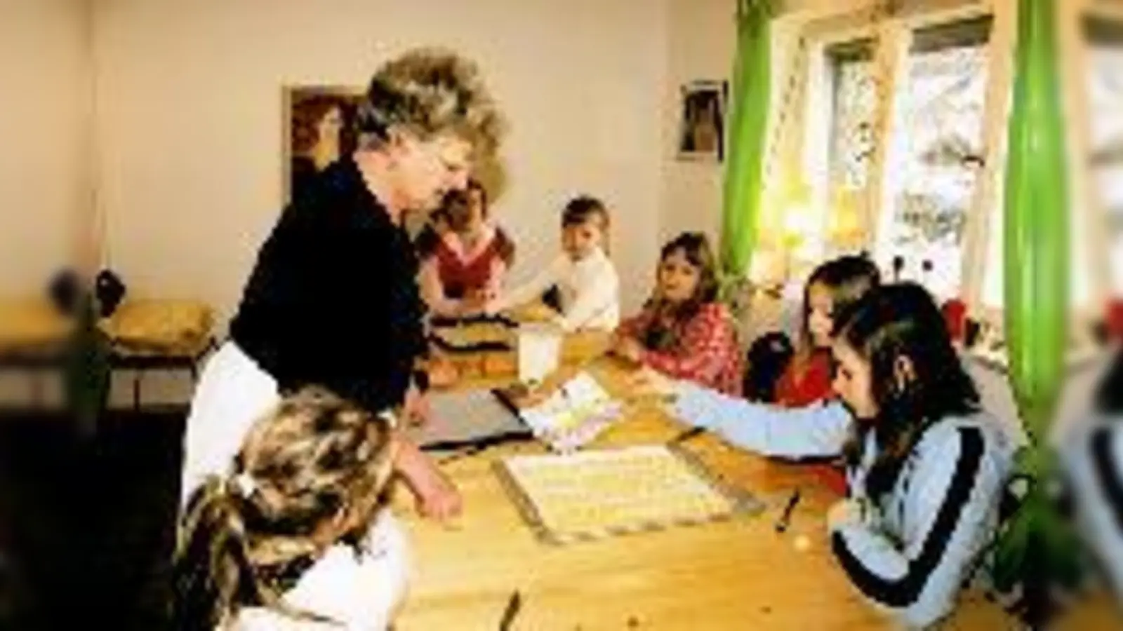 Team-Mitarbeiterin Heidi Ensmann backt Plätzchen mit einer Kindergruppe. (Foto: Tränkel)