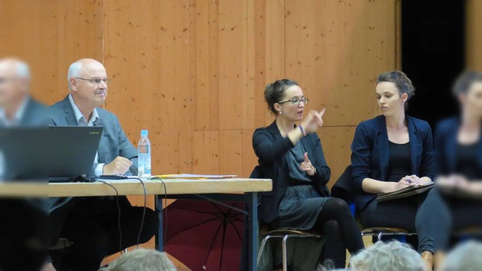 Barrierefreie Bürgerversammlung: Erstmals kamen auch „Dolmetscher für Gebärdensprache und Deutsch“, so lautet die offizielle Bezeichnung, während der Obermenzinger Bürgerversammlung zum Einsatz. Rebecca Sbrzesny (r.) und Carina Hofmann übertrugen alle Reden und Wortbeiträge für Hörgeschädigte in Gebärdensprache. Alle zehn Minuten wechselten sie sich ab. Links im Bild der Vorsitzende des Bezirksausschusses 21, Romanus Scholz. (Foto: us)