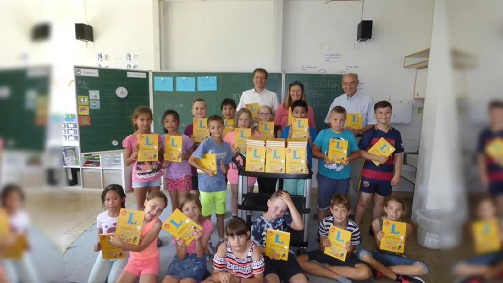 Die Rotarier Gerhard Haimerl (l.) und Alexander von Holstein (r.) besuchten die Theresen-Grundschule und konnten sich davon überzeugen, dass die neuen Englischwörterbücher großen Anklang finden. (Foto: Theresen-Grundschule)