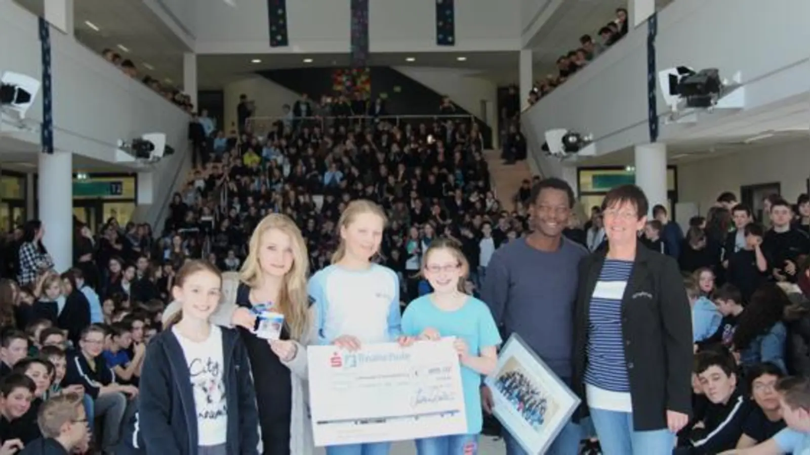 Sozialarbeiter Timothy Nabulwa freute sich über rund 850 Euro für RHU. Die Schüler der Klasse 6d hatten fleißig Spenden gesammelt. Von links: Marlene Kirn, Lucy Hinz, Jana Auer, Katharina Hess und Klassleitung Brigitte Lüken.  (Foto: Realschule Poing)