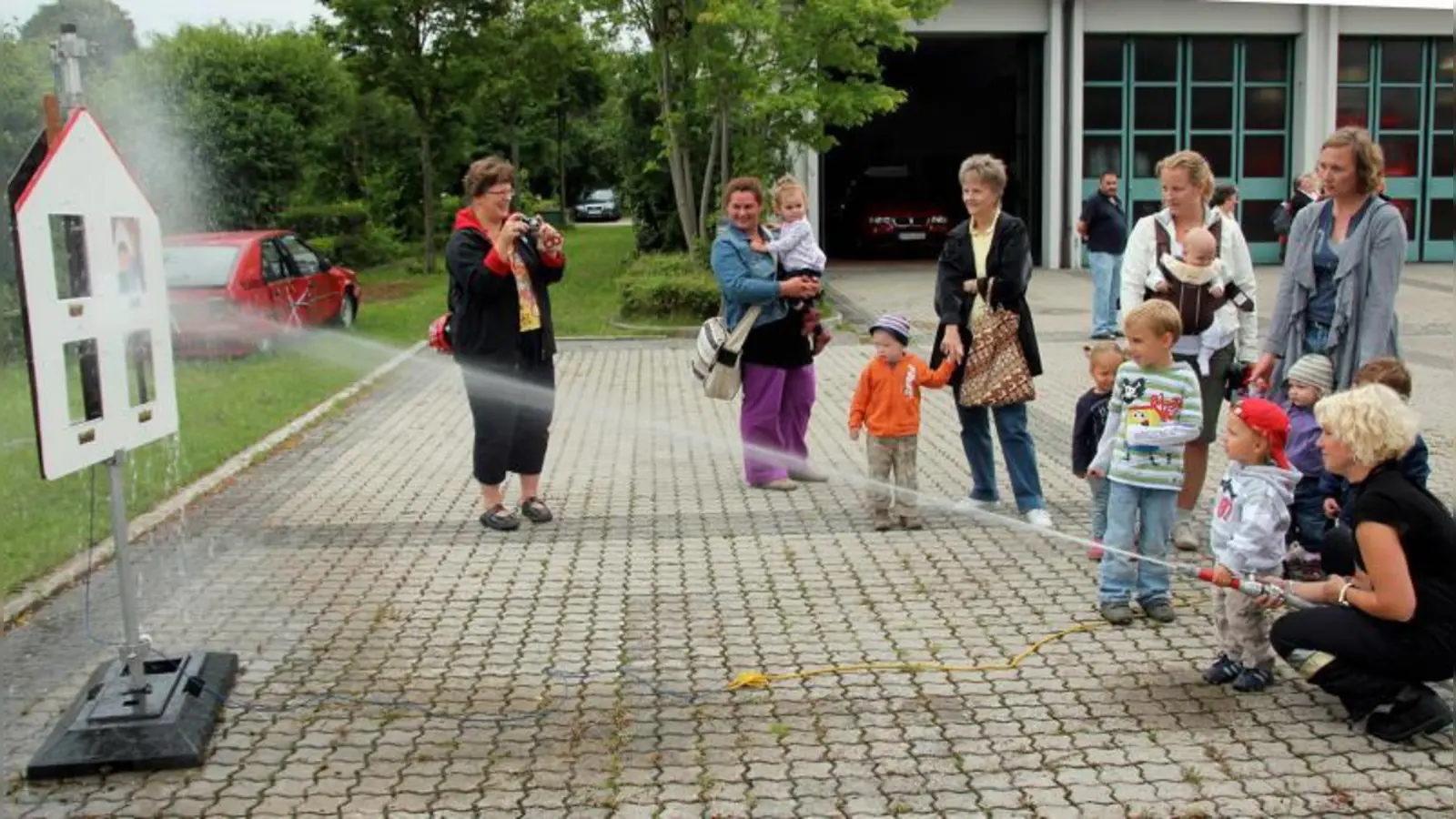 Das Zielspritzen mit dem Feuerwehrschlauch hat Kindern und Müttern der Eltern-Kind-Gruppe bei ihrem Feuerwehrbesuch viel Spaß gemacht. (Foto: pi)