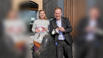 Babybesucherin Kristina Eibl und Landrat Robert Niedergesäß zeigen einige der Willkommensgeschenke. (Foto: LRA)