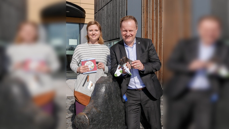 Babybesucherin Kristina Eibl und Landrat Robert Niedergesäß zeigen einige der Willkommensgeschenke. (Foto: LRA)
