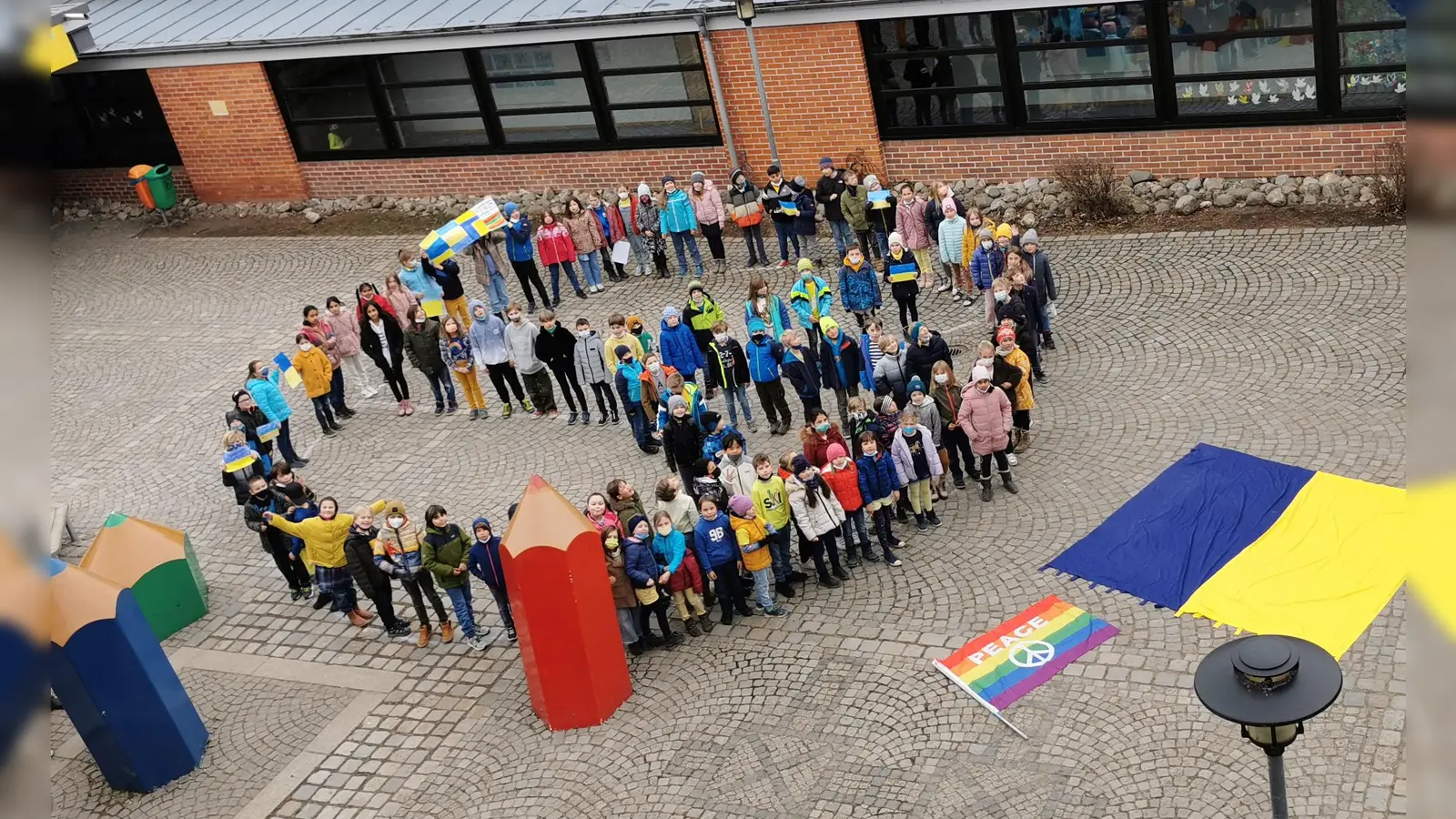 Schüler der Christian-Morgenstern-Grundschule formieren sich zu einem Peace-Zeichen. (Foto: Christian-Morgenstern-Grund- und Mittelschule)
