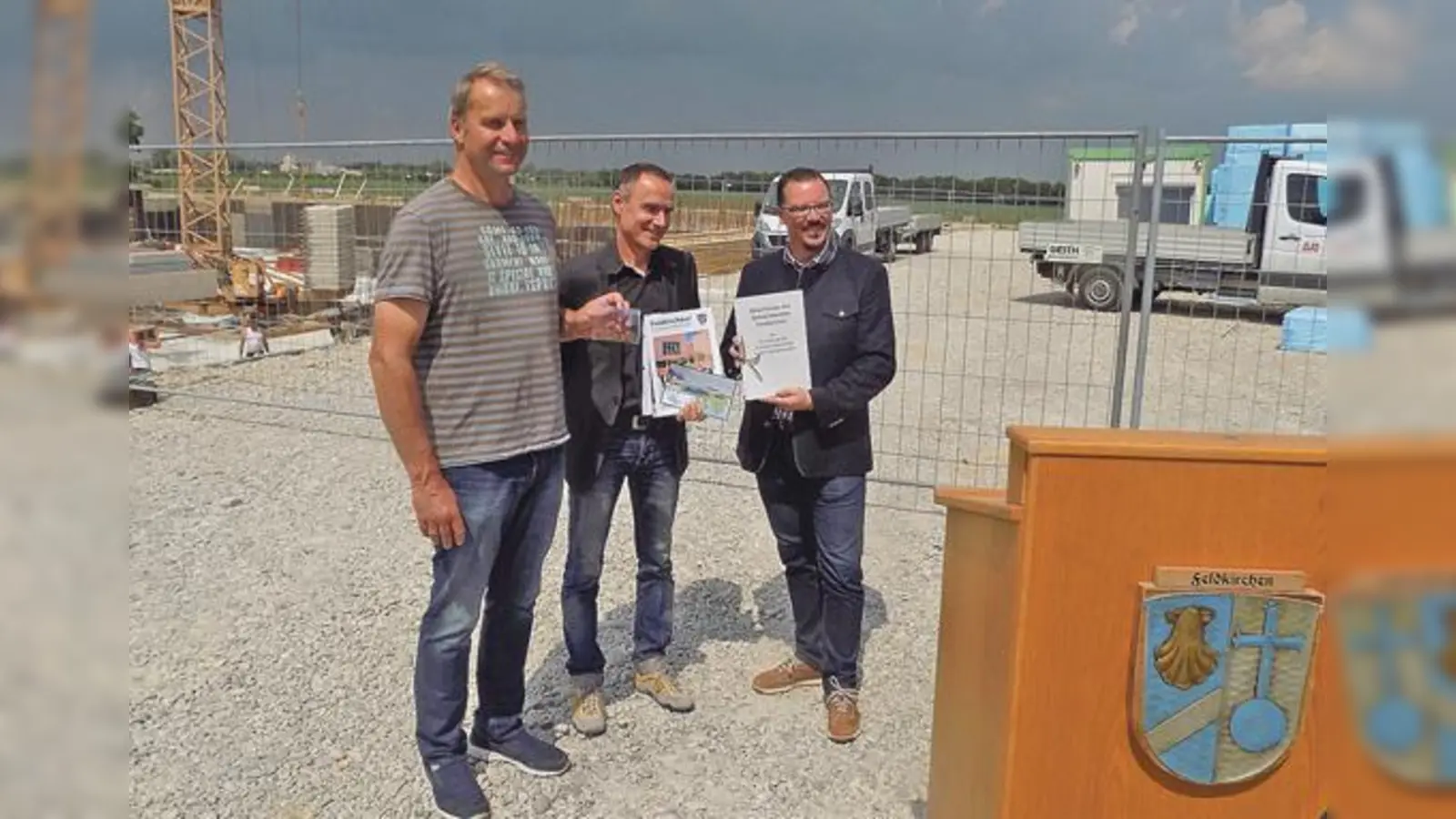 Feldkirchens Zweiter Bürgermeister Andreas Janson, Architekt Marcus Vollmann und Stefan Kräutler, Geschäftsführer der Firma Zeiler Bau (von rechts), mit dem Inhalt der Zeitkapsel für den Grundstein der neuen Dreifachsporthalle.      (Foto: bs)