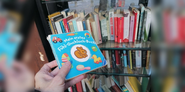 „Mein erstes Fühl-Guckloch-Buch” mit deutlichen Fühlspuren im Bücherschrank in der Isarvorstadt. (Foto: job)