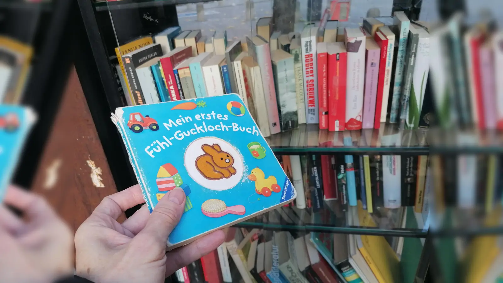 „Mein erstes Fühl-Guckloch-Buch” mit deutlichen Fühlspuren im Bücherschrank in der Isarvorstadt. (Foto: job)