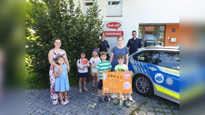 Selbstgebastelte Verkehrsplakate zum Dank: Die Kinder aus dem Kindergarten &amp;quot;Denk mit&amp;quot; freuten sich über den Besuch von Polizeihauptmeisterin Corinna Kolb (hinten links) und Polizeihauptmeister Philipp Rapatz (hinten rechts). (Foto: PI)