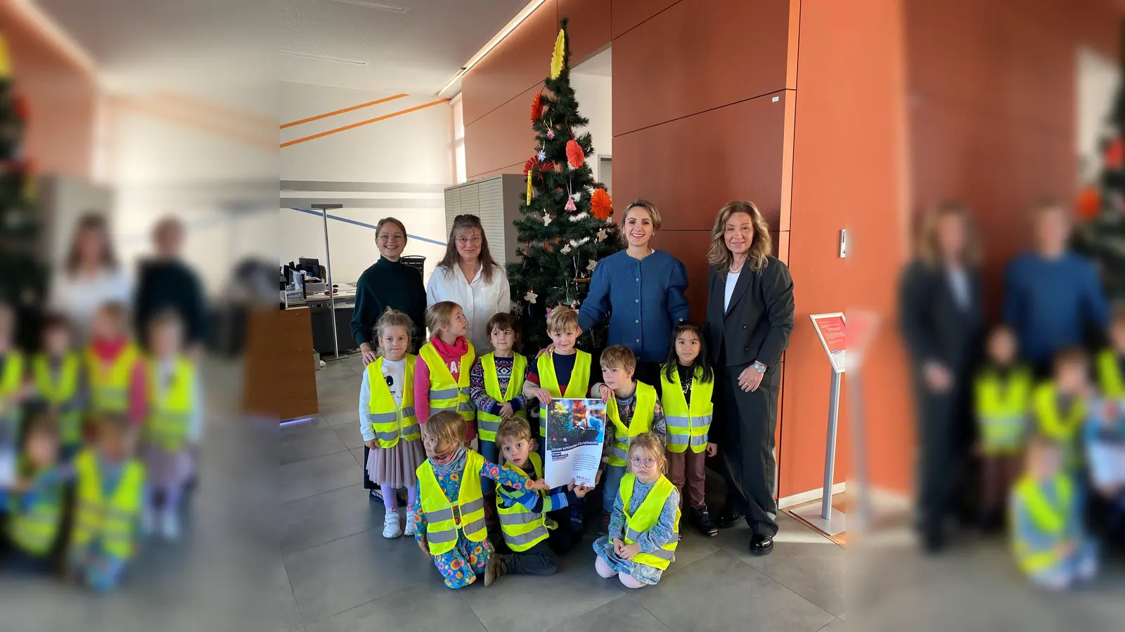 Über den geschmückten Christbaum in der VR Bank Herrsching freuen sich (v.l.) Martina Ullmer (VR Bank), Marina Dollak und Arzana Gerbeshi (Kindertreff Herrsching), Hermine Geng (VR Bank) sowie die Kinder vom Kindertreff. (Foto: Kindertreff Herrsching)
