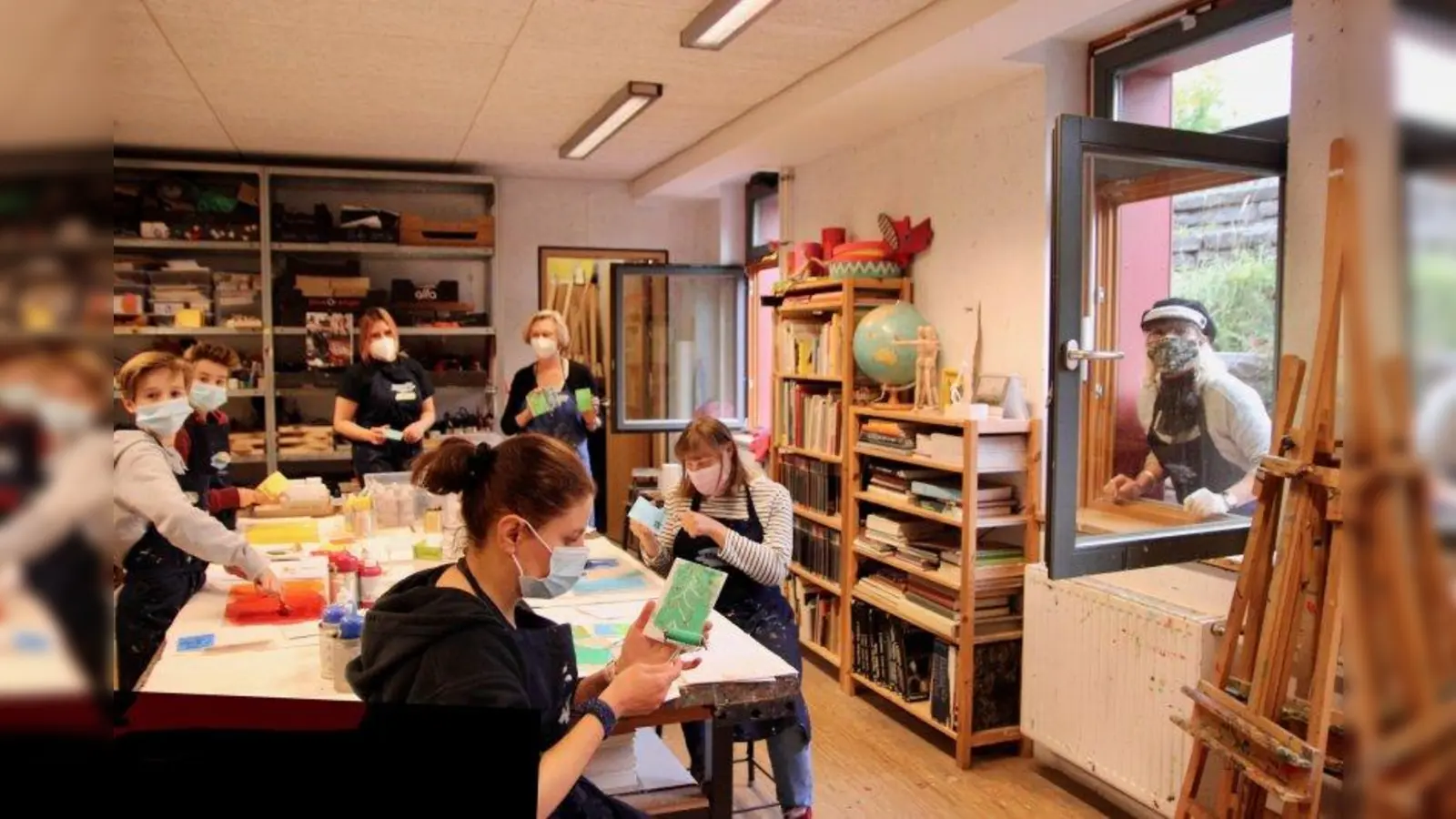 Werkstattatmosphäre bei den Traumwerkerkindern: Gemeinsam mit der Schule der Phantasie druckten sie Postkarten ganz nach dem Motto: „Jede(r) ist anders.” Rechts im Bild Katharina Zörner von den Traumwerkern, im Hintergrund Lilli Plodeck und Lara Oeben von der Schule der Phantasie. (Foto: us)