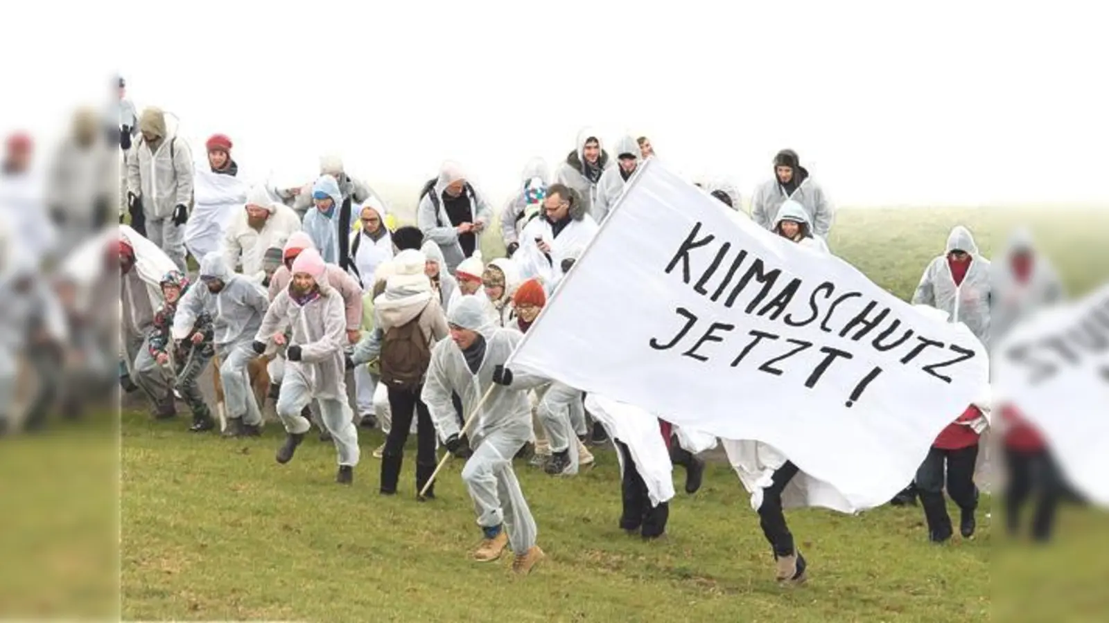 Die weiß gekleideten Teilnehmer des Gipfelmobs färbten den Gipfel des Olympiabergs weiß, um für verbindliche Klimaziele in Paris zu demonstrieren.	 (Foto: Green City, Tobias Hase)