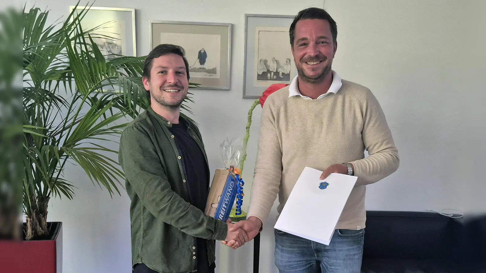 Herzlichen Glückwunsch! Erster Bürgermeister Maximilian Platzer gratuliert Frederic Seifert (l.) zu seinem Abschluss und überreicht den neuen Arbeitsvertrag sowie Kinokarten als Dankeschön für seine in der Ausbildung geleistete Arbeit. (Foto: Gemeinde Gauting)