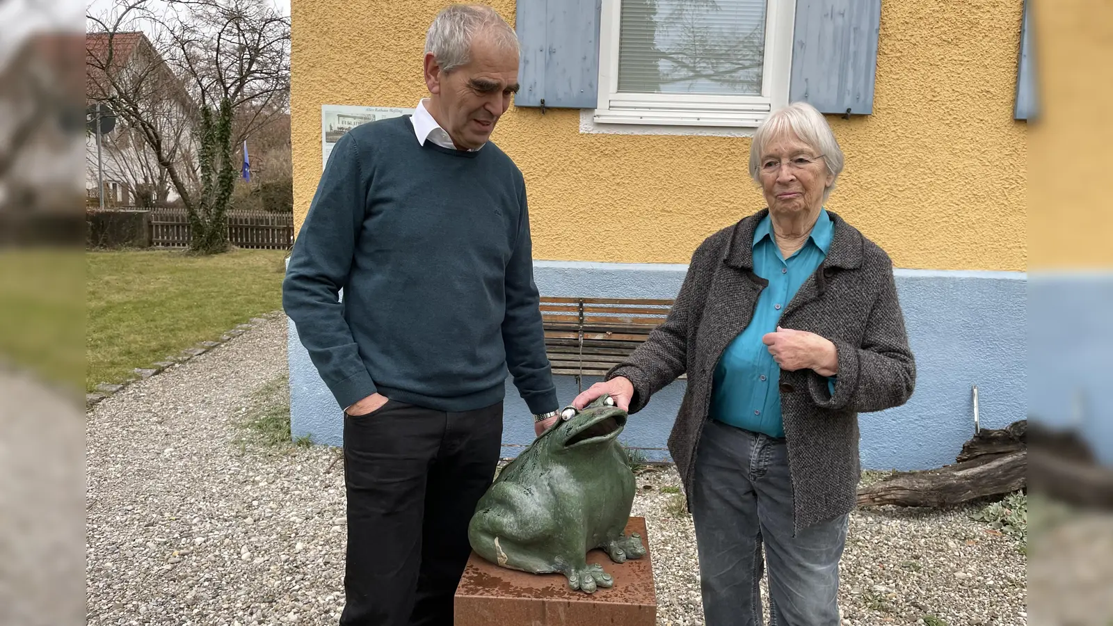 Den grünen Keramikfrosch stellt die Künstlerin Jutta Müller derzeit vor der Gemeindegalerie aus. Mit ihr freut sich Kurator Erich Rüba. (Foto: pst)