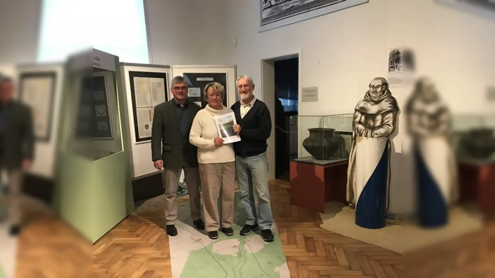 Der Vorsitzende des Fördervereins des Heimatmuseums präsentiert mit den beiden Autoren: Gertraud und Hans-Peter Schubert das Buch über den Hachinger Bach.  (Foto: hw)