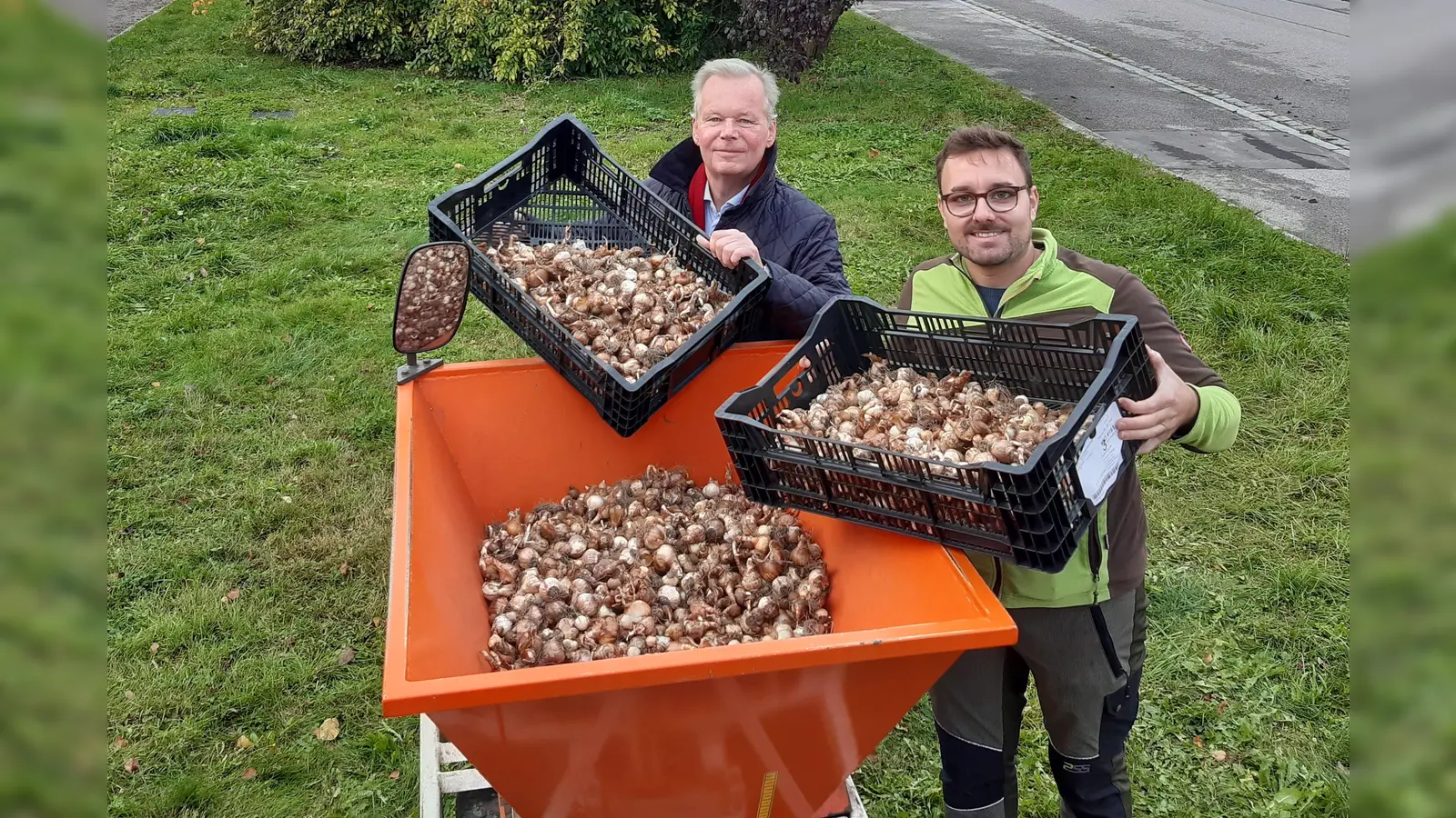  Bürgermeister Jan Neusiedl und Christoph Höning (Umweltamt) befüllen den Trichter der Pflanzmaschine mit Blumenzwiebeln, bestehend aus Krokussen und Narzissen. (Foto: Gemeinde Grünwald)