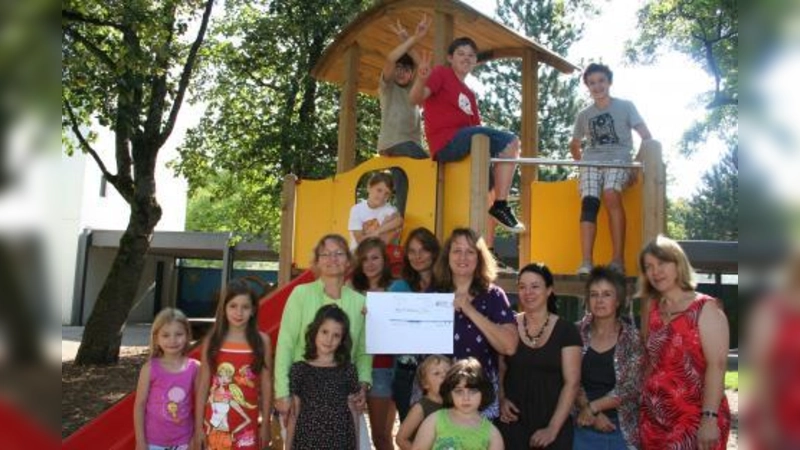 Kinder und Erzieher des Horts „Namen Jesu” freuen sich über die Spende des „Mütterforums”. Alexandra Gaßmann überreichte Kindergartenleiterin Maria Frank-Maana (links) einen symbolischen Scheck. (Foto: tg)