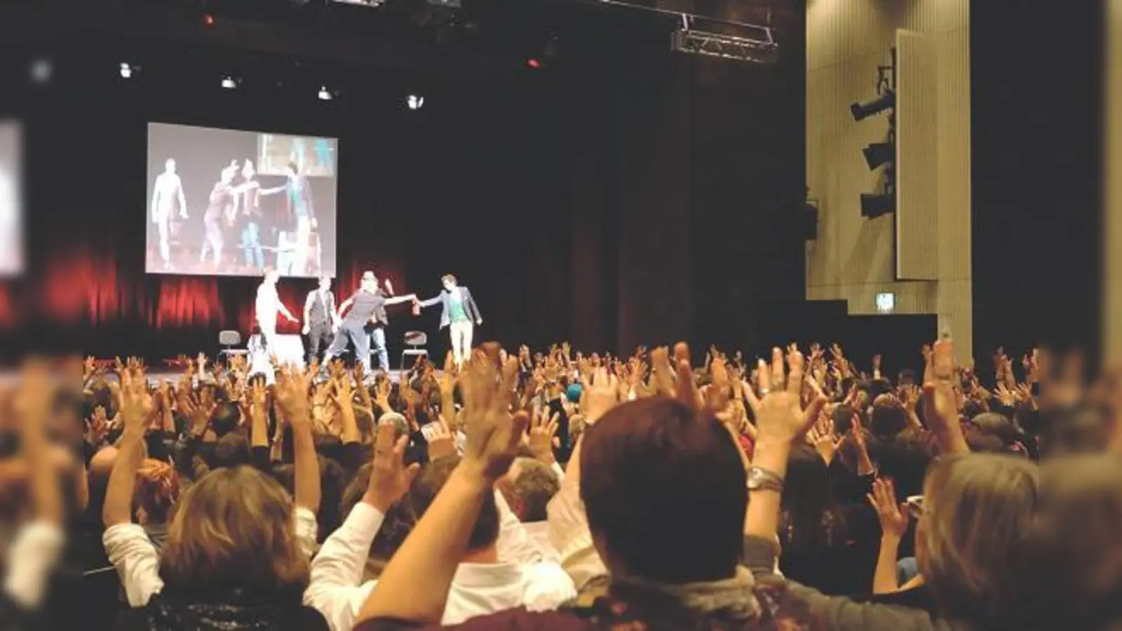 Mit nach oben gereckten Händen applaudierten die Gehörlosen den Theatergruppen beim Degeth-Festival im Bürgerhaus.	 (Foto: Gemeinde Unterföhring)