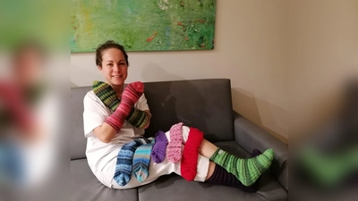 Viviana Dasch, Gesundheits- und Krankenpflegerin der Palliativstation, zeigt die Bettsocken für Patienten, die ihre Kollegin Birgit Berthold gestrickt hat. (F.: Kreisklinik Ebersberg)