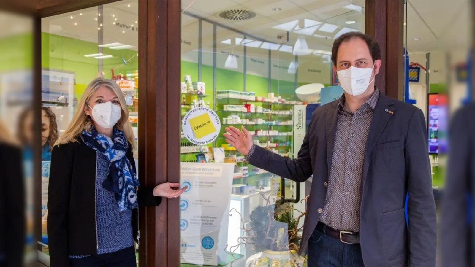 Petra Fontana (Fachstelle für Senioren) und Apotheker Raphael Felber präsentieren das Logo „Demenzfreundliche Apotheke“. (Foto: Landratsamt Starnberg)
