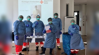 Helfer des BRK werden im richtigen Umgang mit Schutzkleidung ausgebildet. Hierbei wird ressourcensparend Übungsmaterial wiederverwendet. (Foto: BRK)