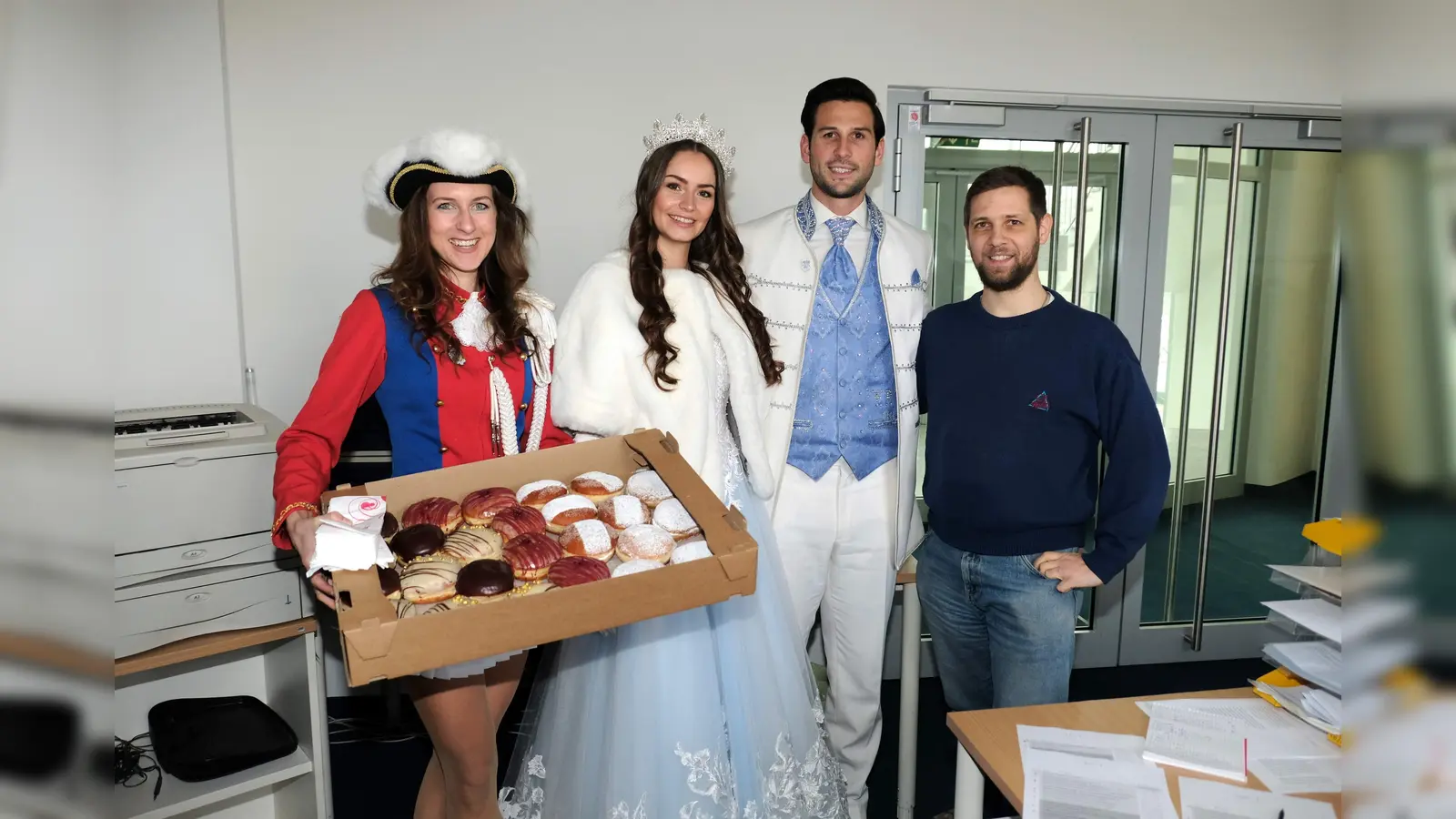 Das Münchner Faschingsprinzenpaar auf Stippvisite in der Redaktion der Münchner Wochenanzeiger. Neben den Krapfen hatten sie noch eine zweite, viel wichtigere Aufmerksamkeit dabei. (Foto: Robert Bösl)