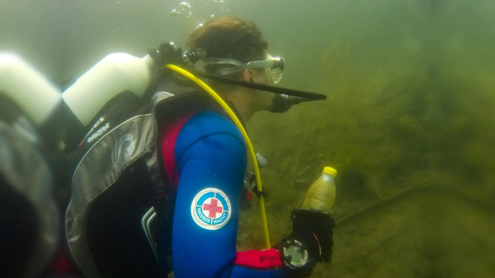 Lucas Daum taucht eine Flasche hoch.  (Foto: BRK)