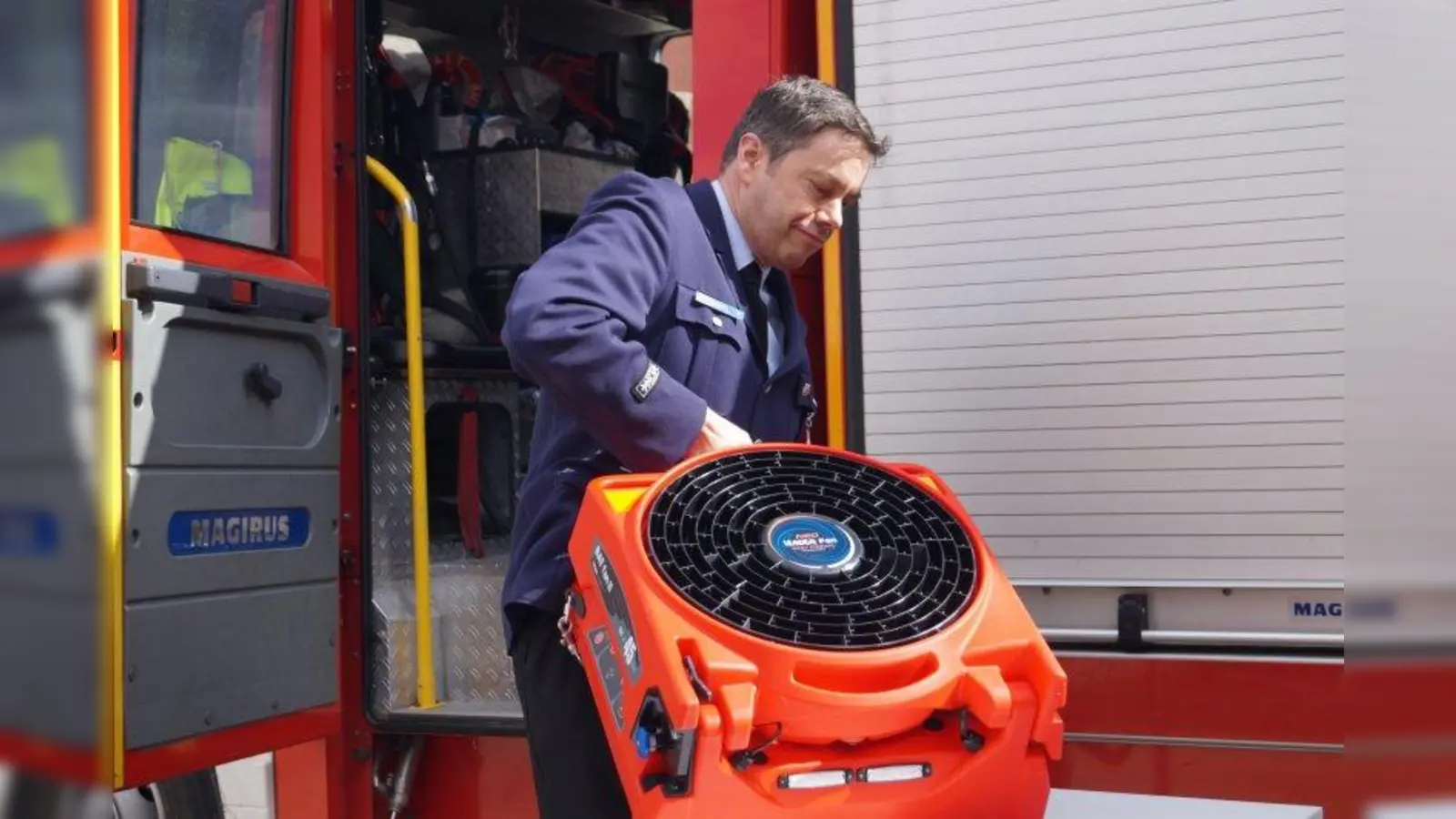 Die 26,5 Kilo des mobilen Lüfters kann Stefan Zankl, Vorstand des Fördervereins der Freiwilligen Feuerwehr Aubing, gut tragen. (Foto: pst)